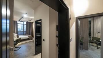 A hotel room with a bed, a desk, a chair, and a bathroom.