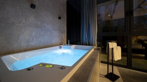 A modern bathroom with a large bathtub, a glass shower enclosure, and a towel rack. - Velvet rooms & more (Zadar)