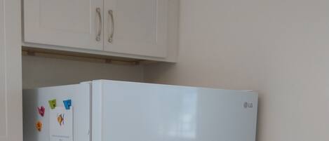 A white refrigerator with a note attached to it.