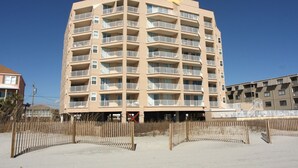 A multi-story hotel with balconies, a sandy beach in front, and a clear blue sky. - Escape to the ultimate beach retreat (North Myrtle Beach)