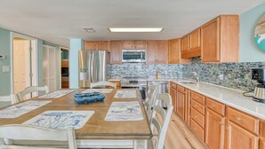 Una cocina con gabinetes de madera, un refrigerador de acero inoxidable, un microondas y una estufa.
