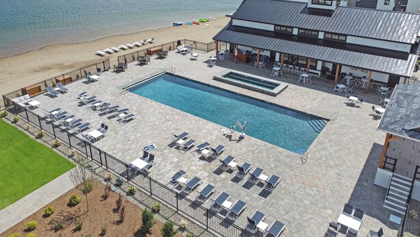 A resort with a swimming pool, sun loungers, and a beach area. - Beautiful resort condo with golf course views (Thornton)