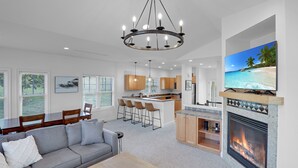 A modern living room with a gray sofa, wooden coffee table, and a fireplace. - Beautiful resort condo with golf course views (Thornton)
