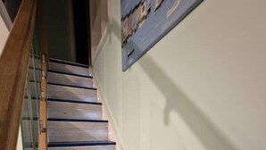 Eine Treppe mit Holzbodenstufen und einem Glasgeländer.