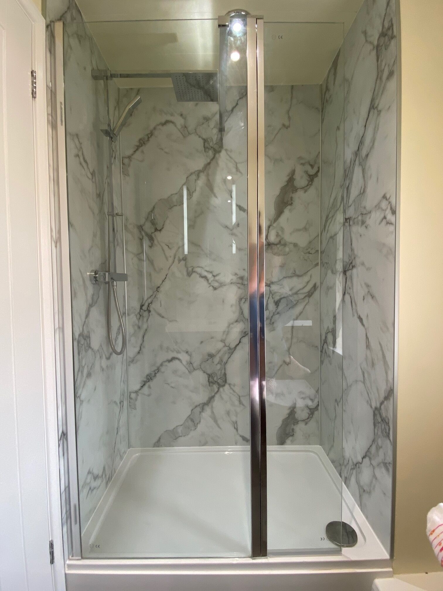 A bathroom with a glass-enclosed shower and a white bathtub.