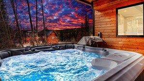 A hot tub with a view of a forest and a house, wooden walls, and a window. - Brand New Construction! Ski-In/Ski-Out Townhome with Private Hot Tub! (Whitefish)