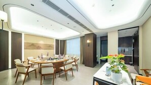 A modern conference room with a round table, white chairs, and a potted plant. - Fuchun Hotel (Fu'an)