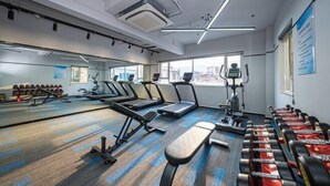 A modern gym with treadmills, elliptical machines, and weight benches. - Fuchun Hotel (Fu'an)