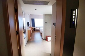 A hotel corridor with a bed, a desk, and a window. - Fuchun Hotel (Fu'an)