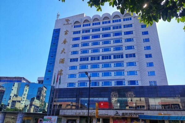 Un hotel de varios pisos con una fachada destacada, que cuenta con una serie de ventanas y una entrada central.
