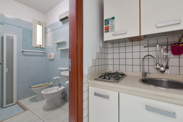 Une salle de bain équipée de toilettes, d’un bidet et d’un lavabo.
