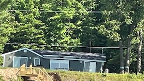 Ett hus med en träterrass och en trappa som leder ner till ett garage.