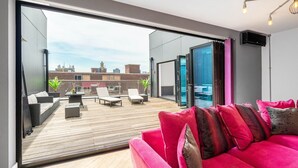 En moderne stue med en stor skydedør, der fører ud til en terrasse.