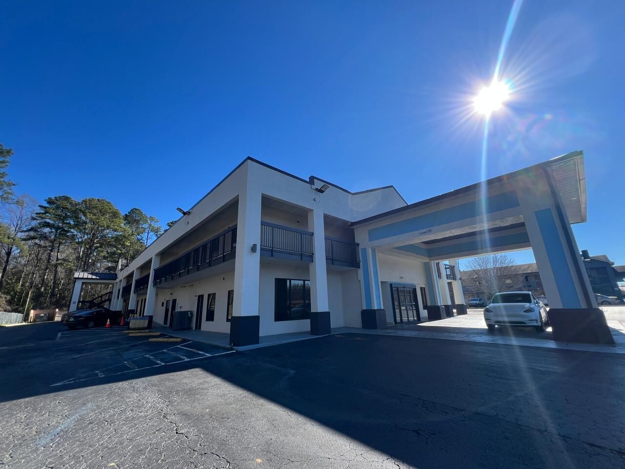 A modern building with a gas station, multiple parking spaces, and a clear sky.