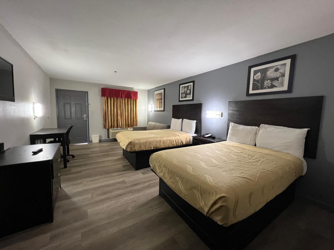 Ein Hotelzimmer mit zwei Betten, einem Schreibtisch und einem Stuhl.