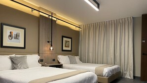A hotel room with two beds, a wooden headboard, a nightstand with a lamp, and a large window with curtains. - Exclusive 409 (Aguascalientes)