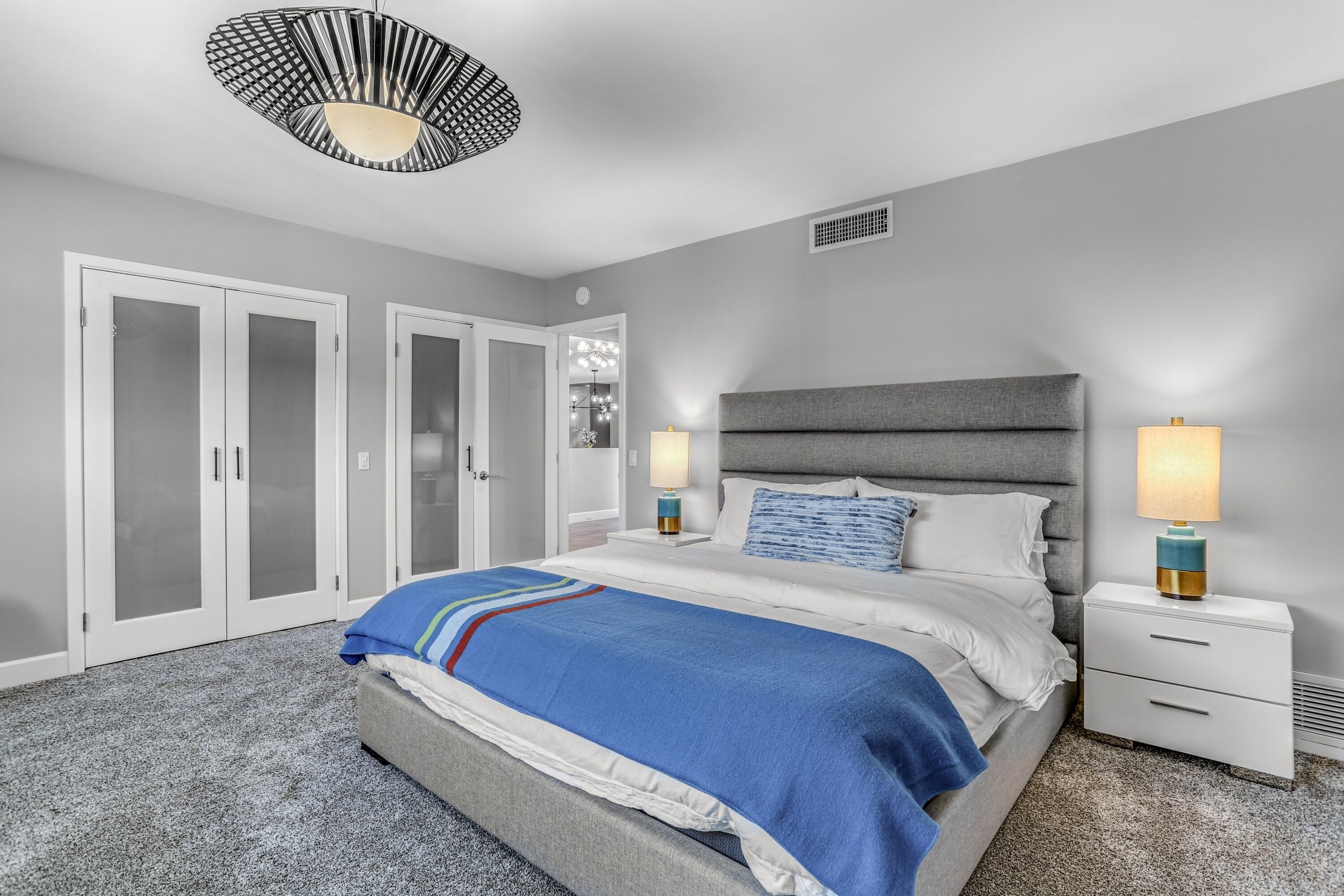 A bedroom with a bed, nightstands, a lamp, and a wardrobe.