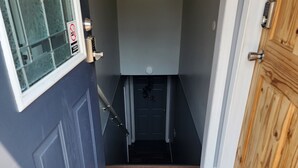 A narrow entryway with a welcome sign, a door with a peephole, and a wooden door to the right. - Country, close to town, sled trails, skiing, large snowmobile boat trailer space (Sault Ste. Marie)