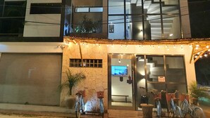Un edificio moderno con entrada de vidrio, zona de estar al aire libre y bicicletas estacionadas afuera.