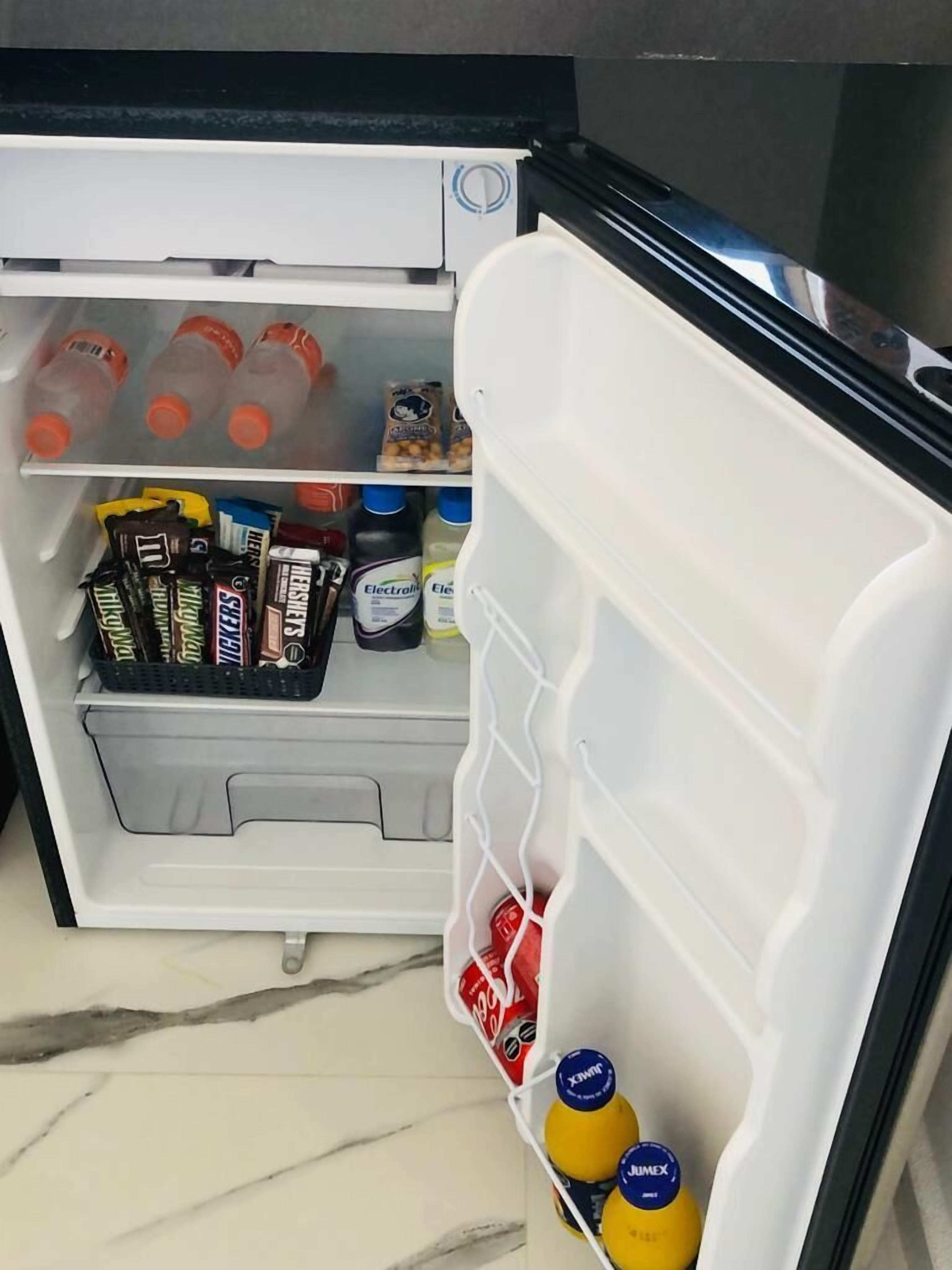 A refrigerator with shelves containing various food items and beverages.