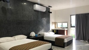 Una habitación de hotel moderna con dos camas, un espejo grande, un lavamanos y vistas al exterior.