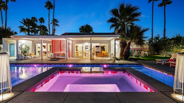 A modern house with a swimming pool, palm trees, and a well-lit patio area. - Birdcage Palm Springs - A Ryson Property (Palm Springs)