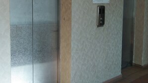 Two elevators with a non-smoking floor sign and a lift button panel. - OYO Home 90533 Nomadic Town Condo (Malacca City)
