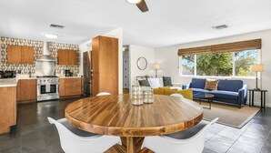 A modern kitchen with wooden cabinets, a stainless steel range hood, and a built-in oven. - Tangerine Desert Dreams - A Ryson Property (Palm Springs)