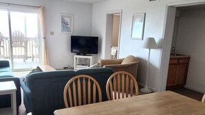 Una sala de estar acogedora con televisión, una mesa de comedor y un sofá.