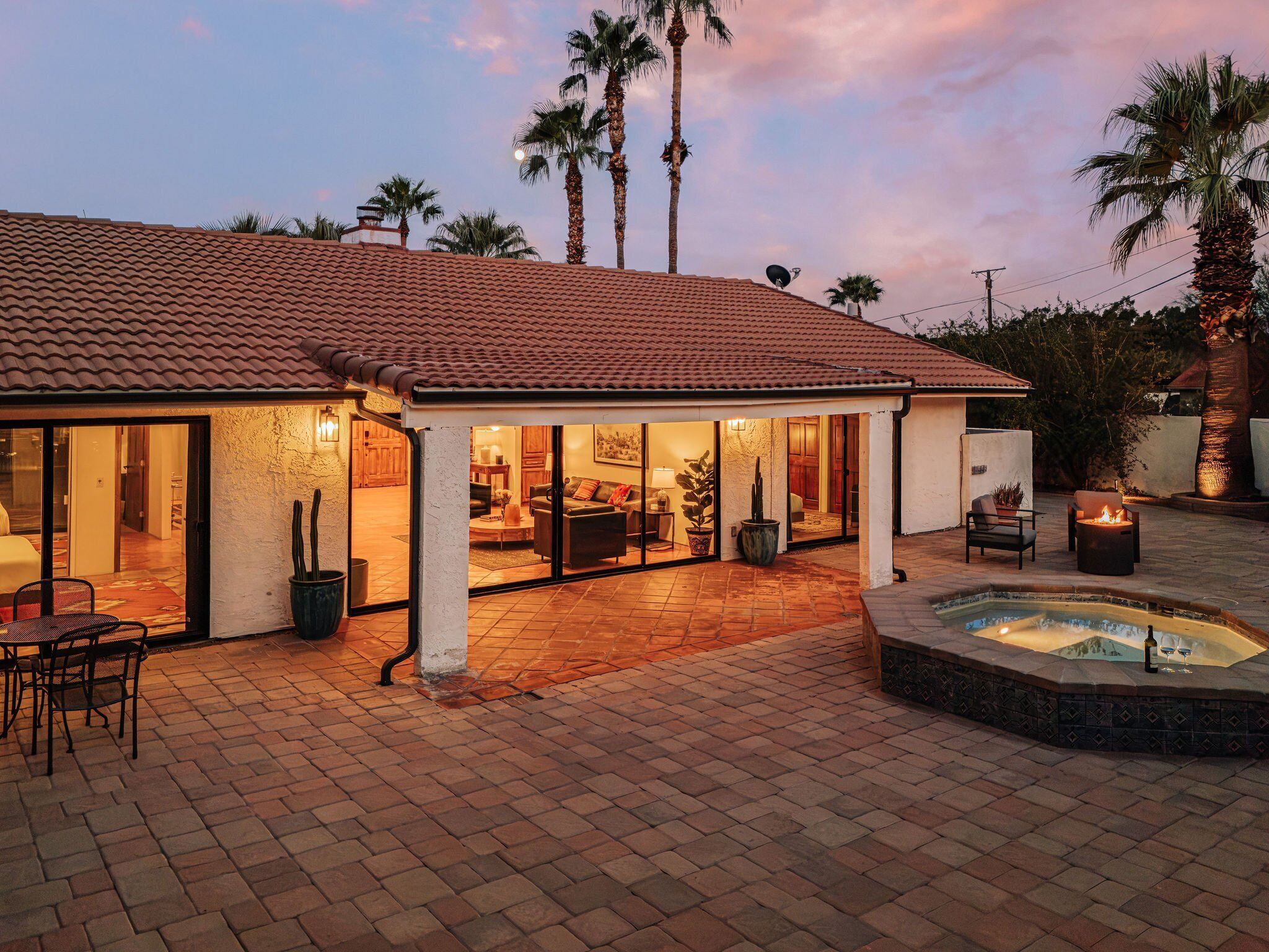 A house with a patio area, a swimming pool, and a covered outdoor seating area.
