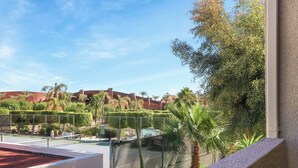 A tennis court with a net, surrounded by a fence and palm trees. - Convenient & Cozy Downtown - A Ryson Property (Palm Springs)