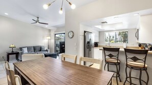 Een moderne keuken met een eethoek, een plafondventilator en een groot raam.