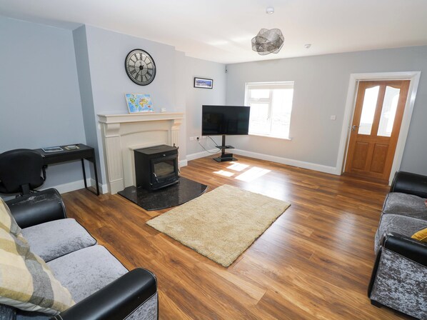 A living room with a fireplace, a television, and a sofa.