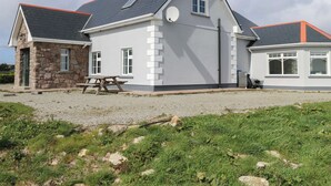 A two-story house with a stone foundation, a grey exterior, and a red roof. - Tí Tom Nárta (Teeranea)