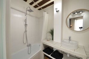 Bathtub, hair dryer, towels, toilet paper