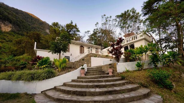 Un edificio blanco con una escalera de piedra que lleva a un balcón.