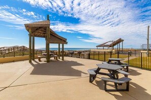 A beachside patio with picnic tables and a wooden shelter. - Phoenix II 2012 (Orange Beach)