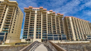 A multi-story hotel with a central walkway leading to the entrance. - Phoenix II 2012 (Orange Beach)