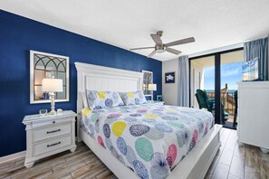 A bedroom with a bed, a nightstand, a ceiling fan, and a view of the outside. - Phoenix II 2012 (Orange Beach)