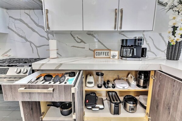 Una cocina moderna con estación de café, hervidor, tostadora y licuadora.