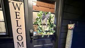 A dark wooden door with a 'WELCOME' sign, a wreath, and a striped decorative item beside it. - Cozy Manchester Getaway with Amazing Views!!! (Winhall)