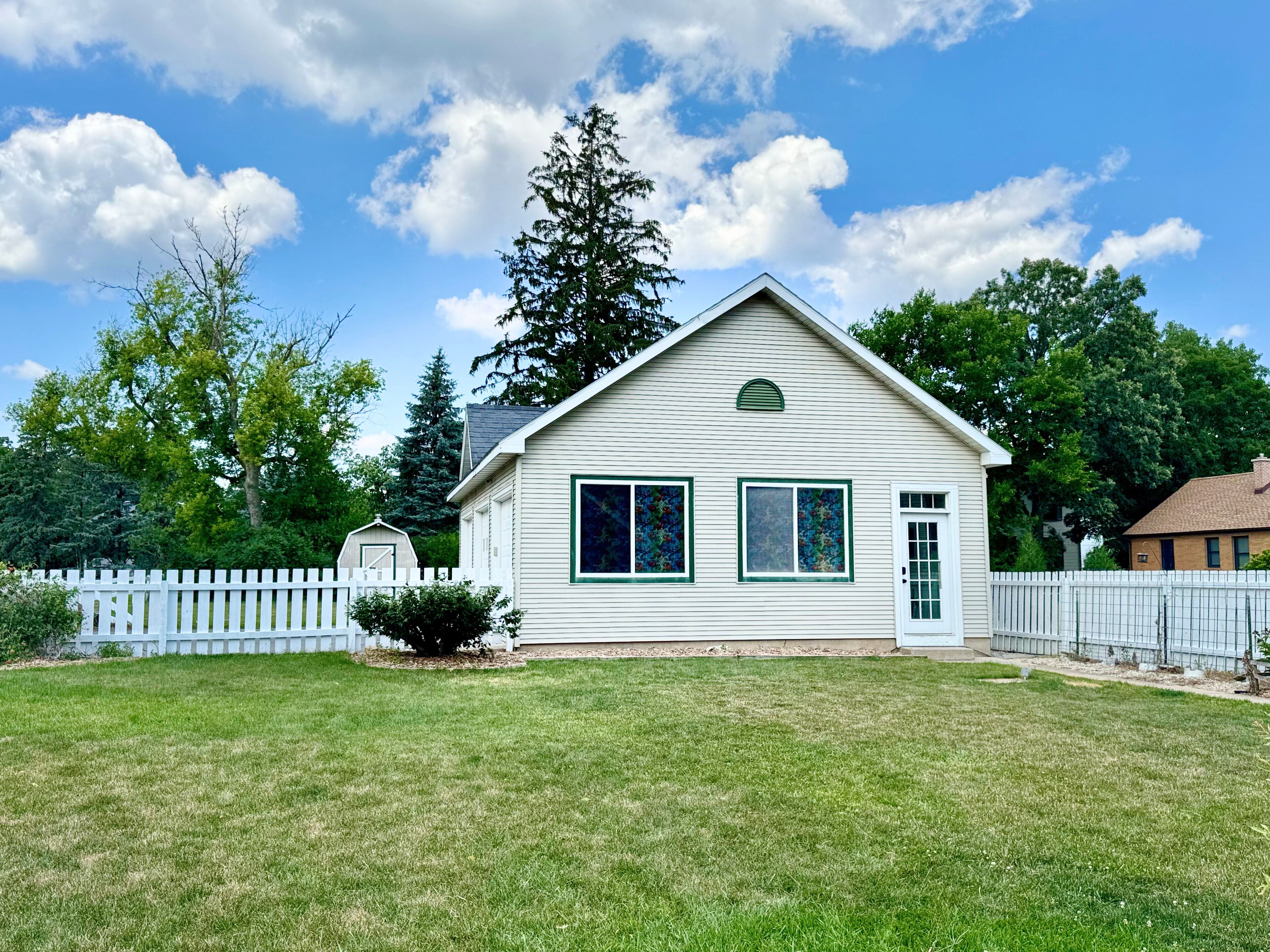 A single-story house with a gabled roof, a front porch, and a small front yard.