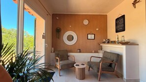 A cozy seating area with two chairs, a small round table, and a wooden wall with decorative elements.