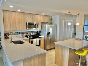 A newly renovated kitchen with stainless steel appliances and laundry room. 
