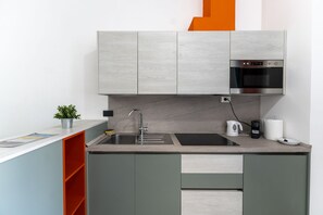 Une cuisine moderne équipée d’un four encastré, d’un évier et d’un plan de travail.