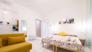 Un dormitorio moderno con una cama, un sofá y una mesita.