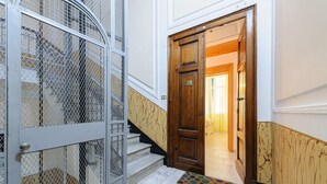Una escala amb una porta de fusta i una reixa metàl·lica.