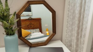 A bedroom with a bed, a bedside lamp, a laptop, and a mirror on a white dresser. - Napolicentrico - Three Bedroom Apartment, Sleeps 8 (Napoli)