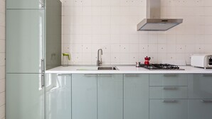 Une cuisine équipée d’un évier, d’une cuisinière et de placards.