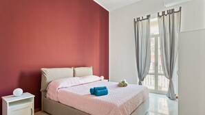 Une chambre à coucher avec un lit, une table de chevet et une fenêtre avec des rideaux.